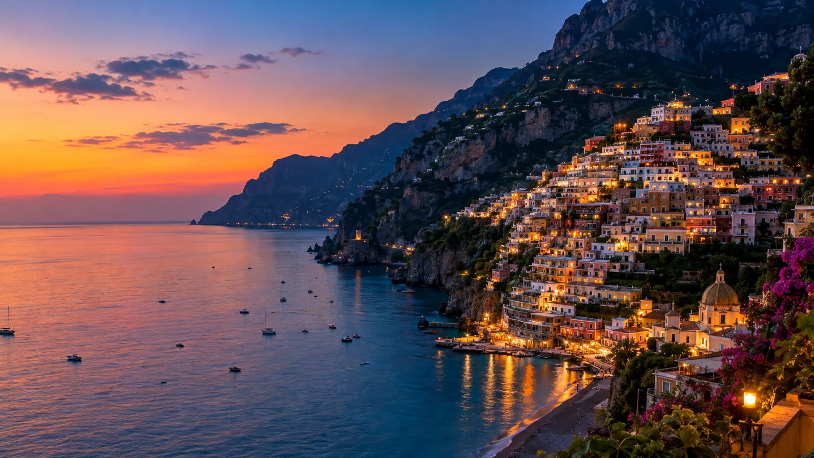 The Amalfi Coast cliffs and a village lit up at dusk