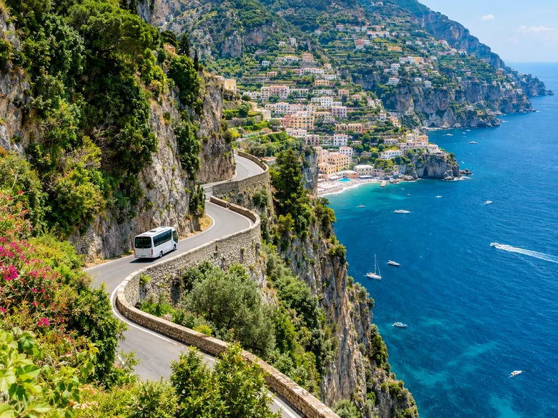 Minibus on the winding Amalfi Coast cliff road above the sea