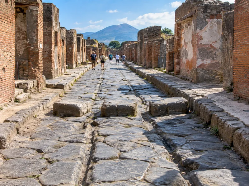 Ancient paved street in Pompeii with stepping stones and ruined houses