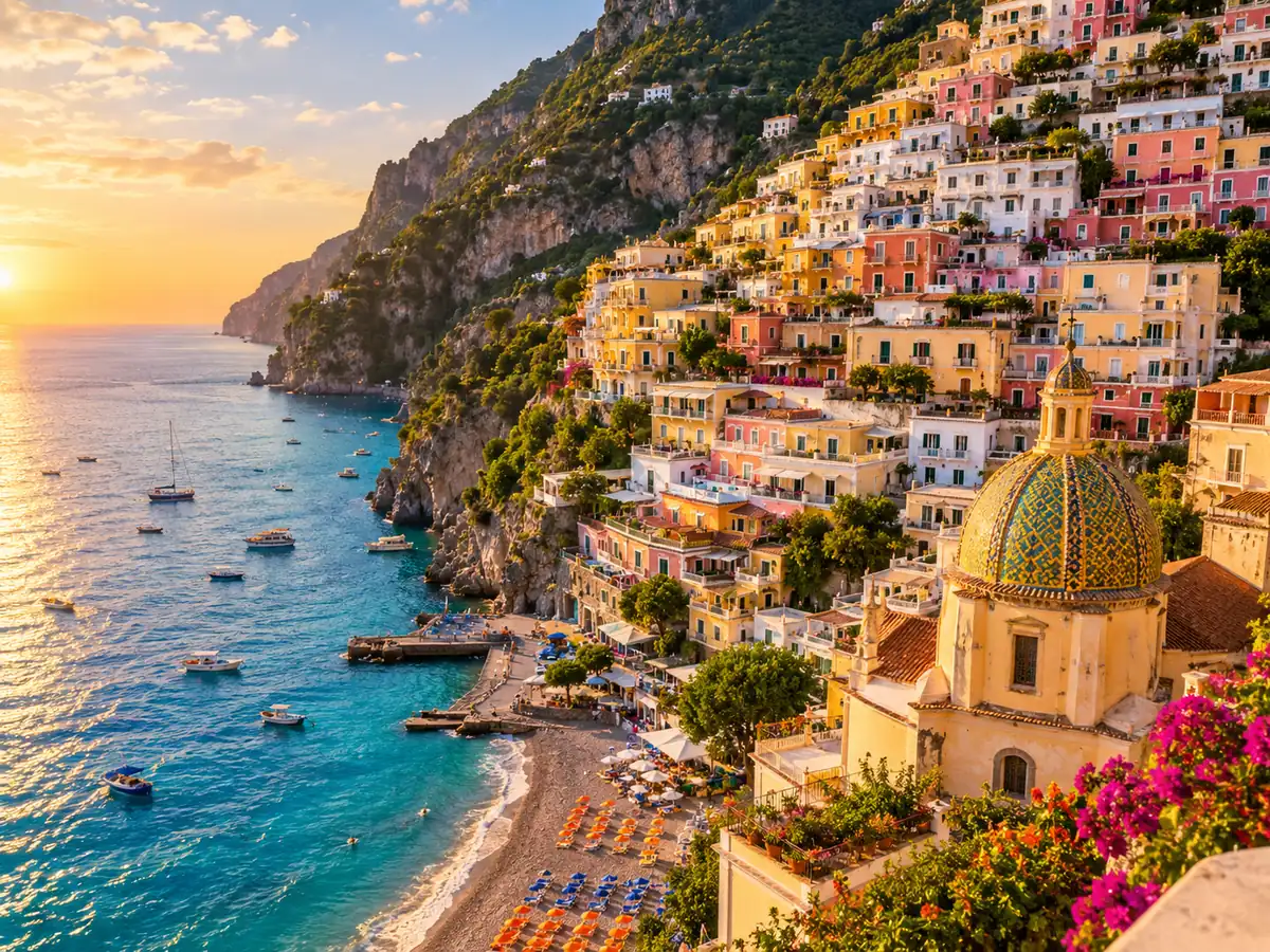 Pastel houses of a cliffside village on the Amalfi Coast above a beach